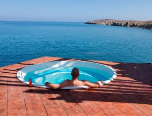 A fisherman looking out over the Pacific Ocean from a hot tub on Cedros Island.